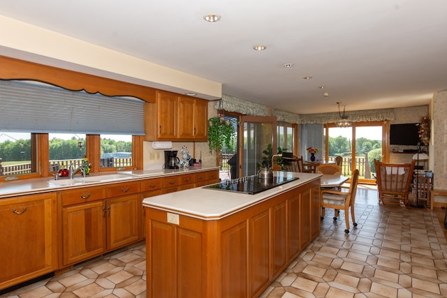 kitchen with a healthy amount of sunlight, black electric stovetop, and light tile floors