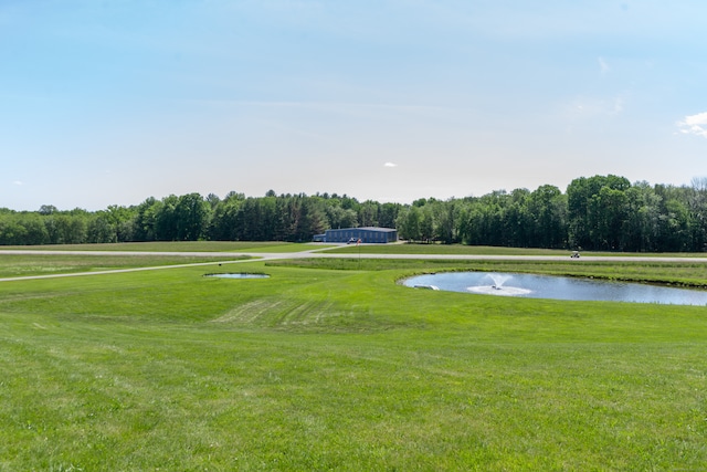 view of property's community with a lawn and a water view