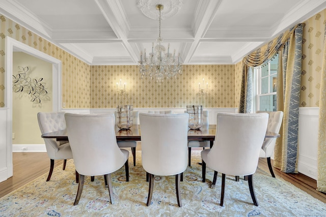 dining area featuring hardwood / wood-style floors, beamed ceiling, a chandelier, coffered ceiling, and crown molding