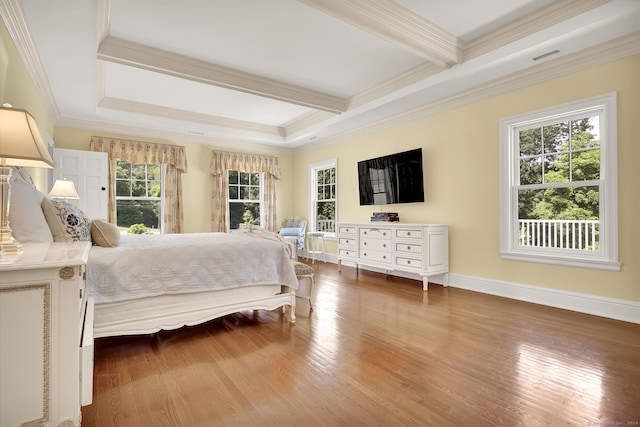 bedroom featuring beamed ceiling, hardwood / wood-style floors, and multiple windows