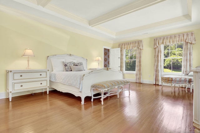 bedroom featuring beamed ceiling, crown molding, a raised ceiling, and light hardwood / wood-style flooring