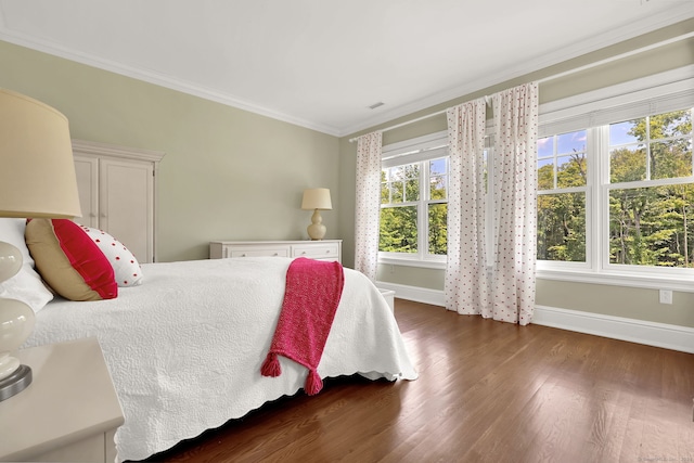 bedroom featuring crown molding and dark wood-type flooring