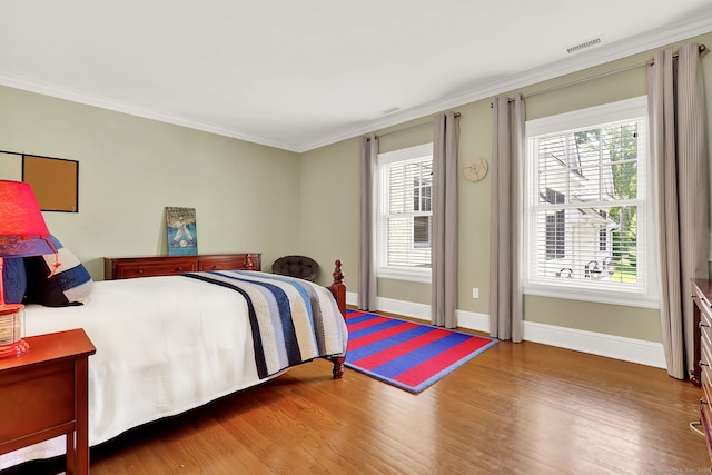 bedroom with hardwood / wood-style flooring and crown molding