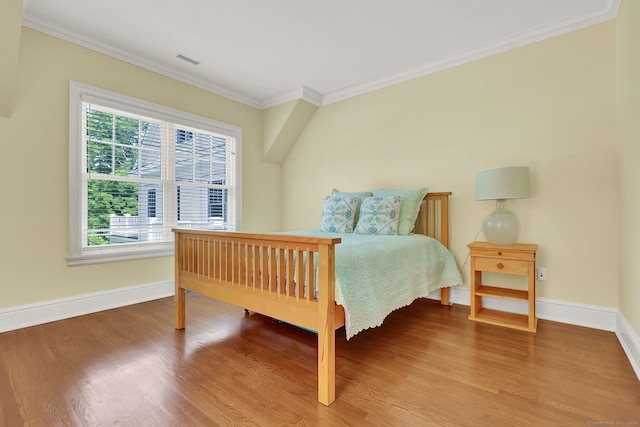 bedroom with hardwood / wood-style flooring and ornamental molding