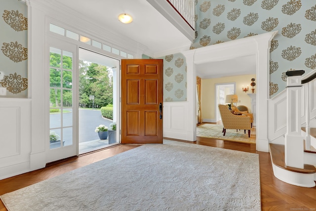 entrance foyer featuring parquet floors and crown molding