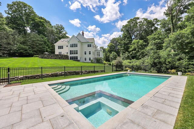 view of swimming pool with an in ground hot tub and a lawn