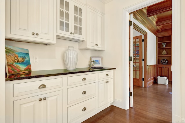 bar with crown molding, dark hardwood / wood-style floors, and white cabinets