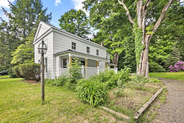 exterior space with covered porch and a yard