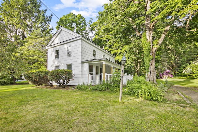 view of side of home with a porch and a yard