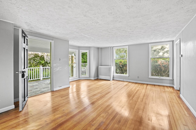 empty room featuring radiator heating unit and light wood-type flooring