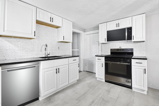 kitchen featuring decorative backsplash, sink, white cabinetry, and appliances with stainless steel finishes