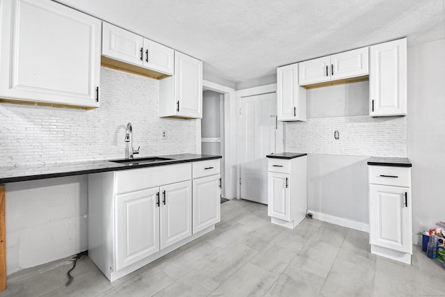 kitchen with sink, backsplash, and white cabinets