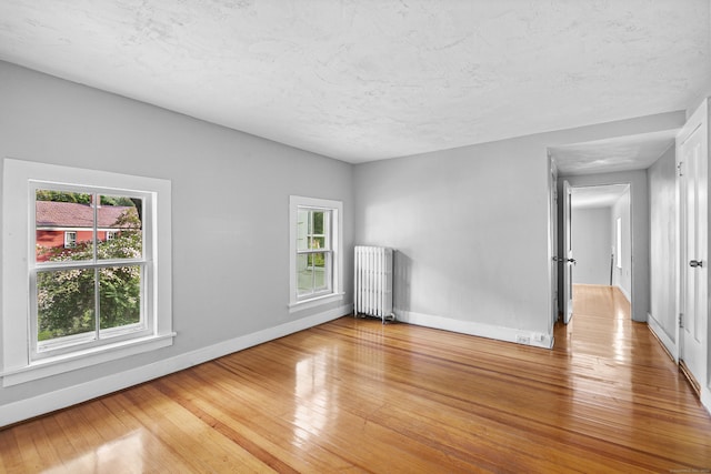 unfurnished room with hardwood / wood-style flooring and radiator