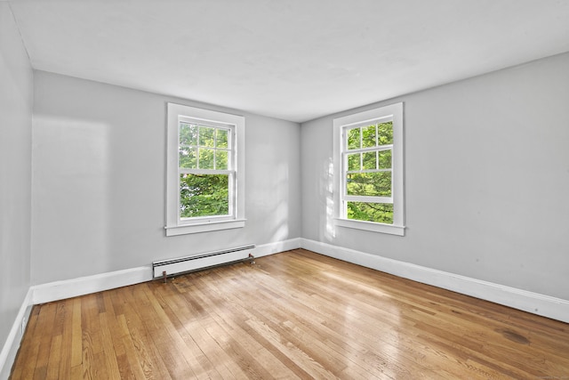 unfurnished room with baseboard heating, a healthy amount of sunlight, and light wood-type flooring