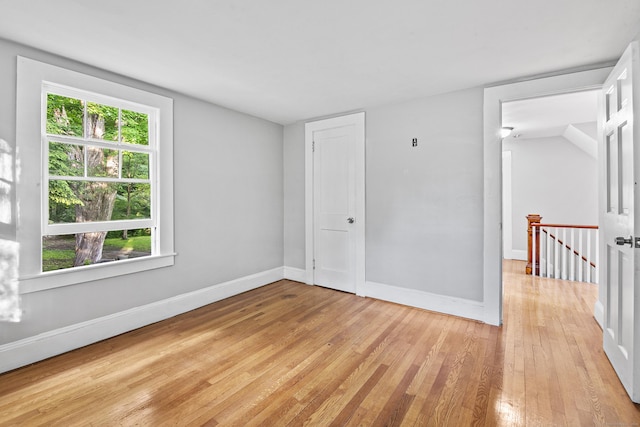 unfurnished room with light hardwood / wood-style floors and vaulted ceiling