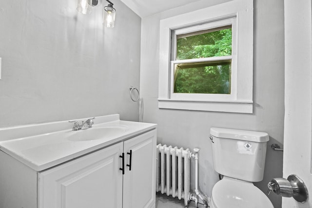 bathroom with vanity, toilet, and radiator heating unit