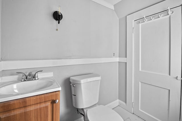 bathroom with vanity, toilet, and crown molding