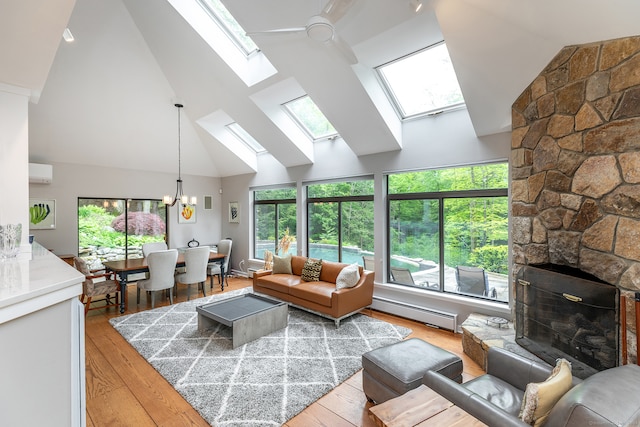 living room with light hardwood / wood-style floors, a fireplace, a skylight, and a wealth of natural light