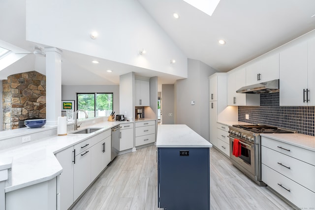 kitchen featuring appliances with stainless steel finishes, white cabinetry, a center island, and sink