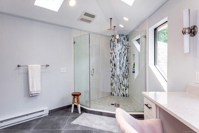 bathroom featuring vanity, a skylight, a shower with shower door, a baseboard heating unit, and tile patterned flooring