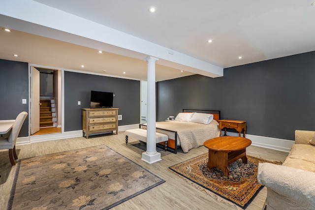 bedroom featuring wood-type flooring and ornate columns