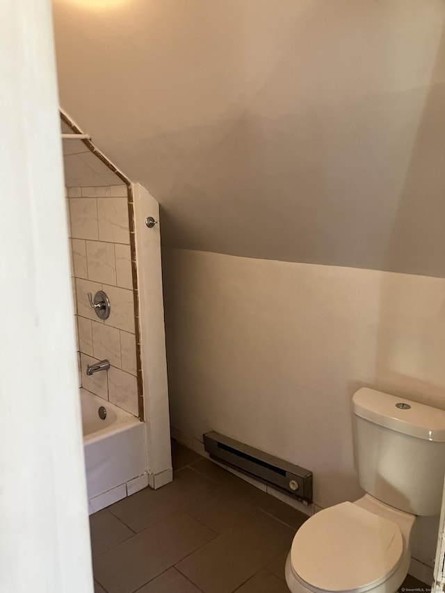 bathroom featuring baseboard heating, tile patterned flooring, tiled shower / bath combo, vaulted ceiling, and toilet