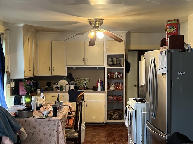 kitchen featuring dark parquet flooring, white cabinetry, stainless steel refrigerator, white range with gas cooktop, and ceiling fan