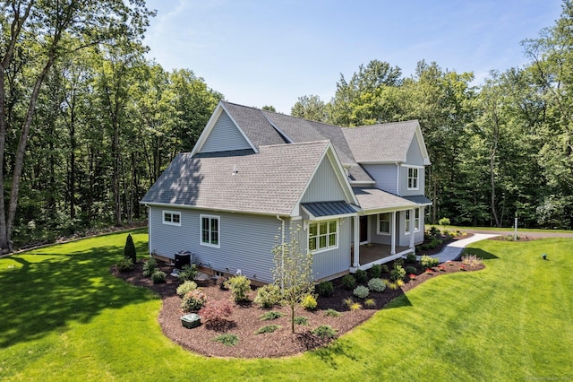 view of side of home with a lawn, central air condition unit, and covered porch