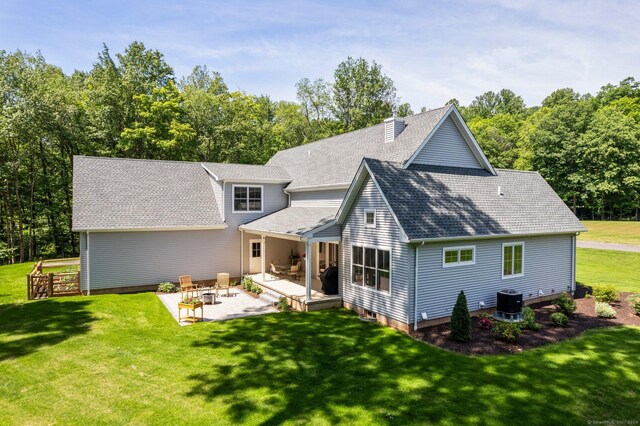 rear view of house featuring a yard, a patio, and central AC unit