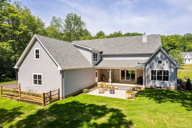 back of property with a lawn and a patio