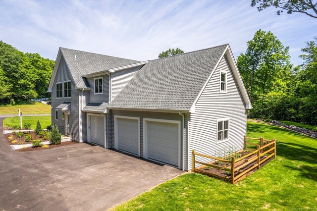 view of side of home featuring a garage and a yard