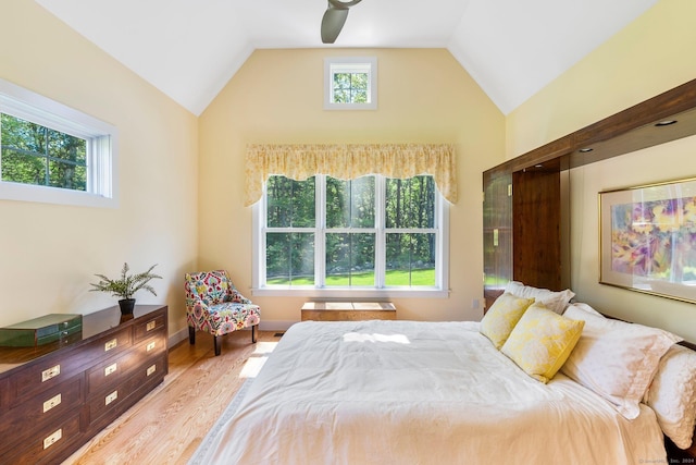 bedroom featuring ceiling fan, light hardwood / wood-style floors, and lofted ceiling