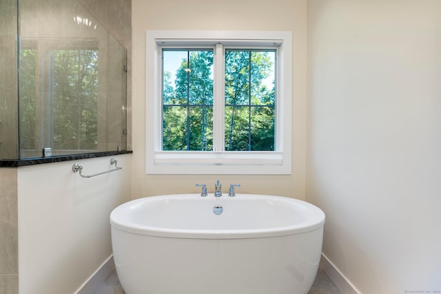 bathroom with tile patterned floors and a tub