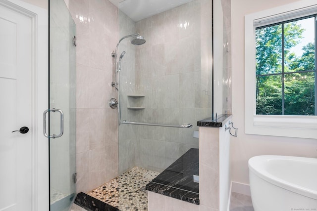 bathroom featuring separate shower and tub and plenty of natural light