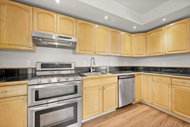 kitchen with sink, light brown cabinets, light wood-type flooring, and appliances with stainless steel finishes