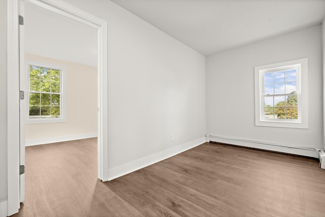 spare room featuring a baseboard radiator and hardwood / wood-style floors