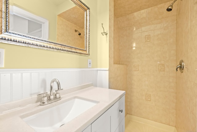 bathroom with tiled shower and vanity