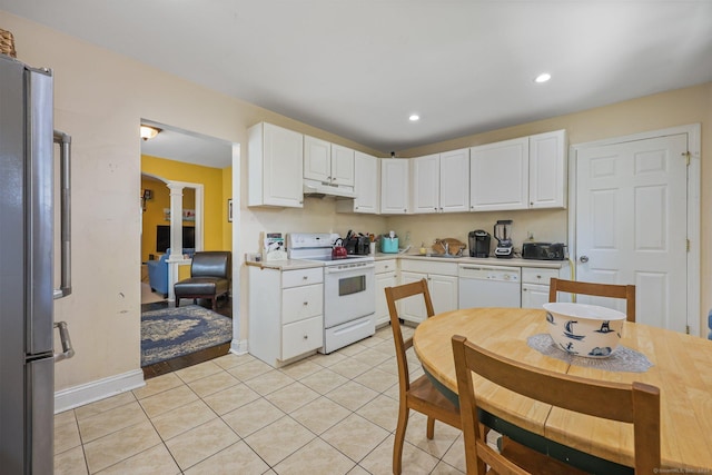 kitchen featuring white appliances, white cabinets, light tile patterned flooring, and sink