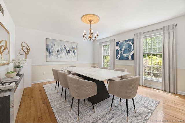 dining area featuring an inviting chandelier and light hardwood / wood-style floors