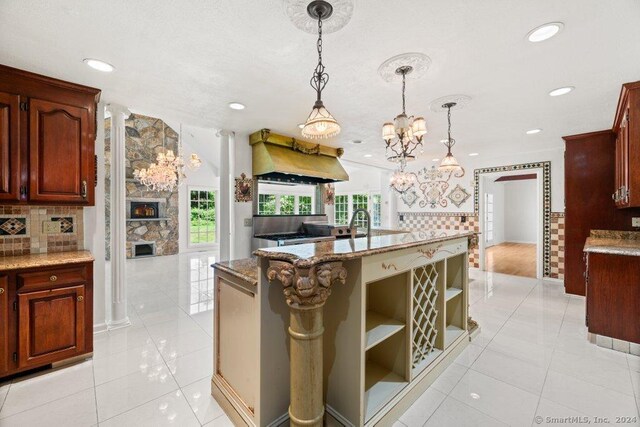 kitchen featuring hanging light fixtures, light tile patterned floors, custom exhaust hood, and a chandelier