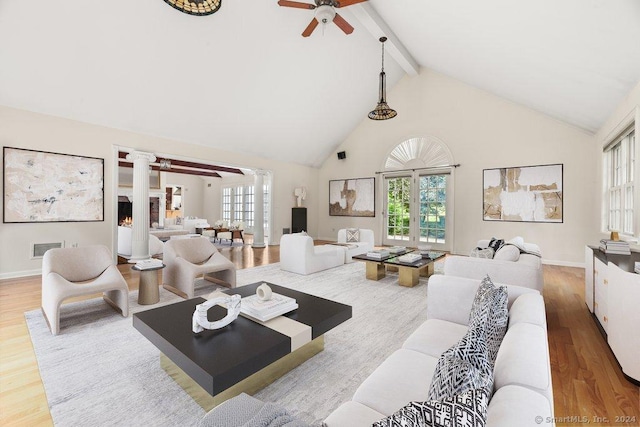 living room featuring ornate columns, a fireplace, beamed ceiling, hardwood / wood-style flooring, and ceiling fan