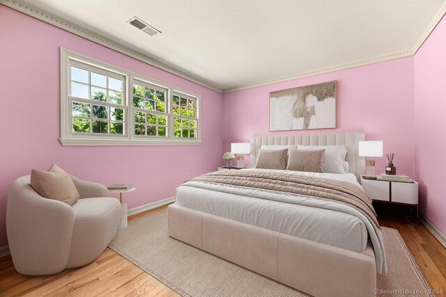 bedroom with crown molding and wood-type flooring