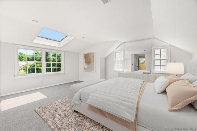 bedroom featuring lofted ceiling with skylight and carpet