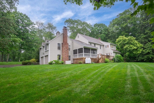 18 Hunters Ridge Rd, Southbury, CT 06488 - back of house featuring a sunroom, a chimney, a garage, and a yard