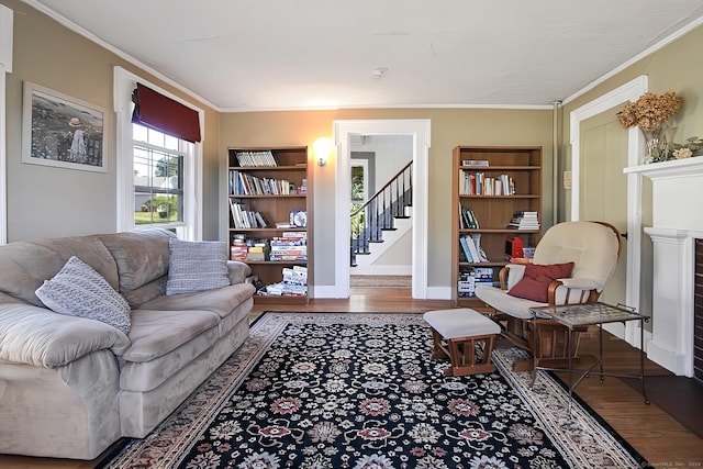 living room featuring a fireplace, crown molding, and hardwood / wood-style floors