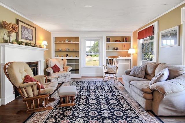 living room with a fireplace, hardwood / wood-style floors, built in shelves, and crown molding