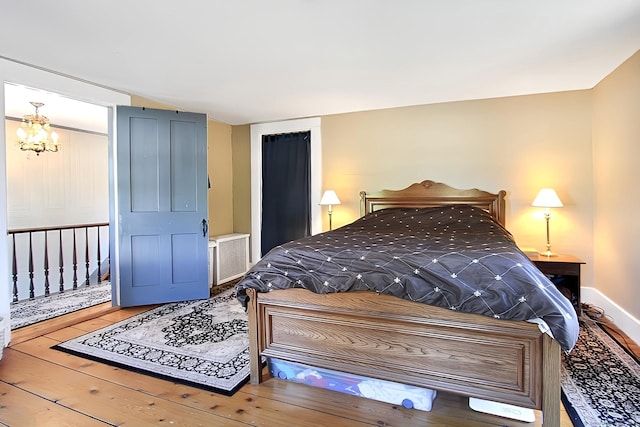 bedroom featuring hardwood / wood-style flooring and a notable chandelier