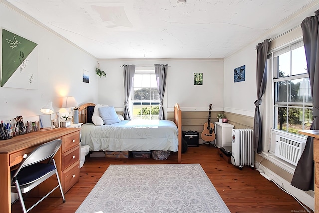 bedroom with radiator heating unit, dark wood-type flooring, and ornamental molding