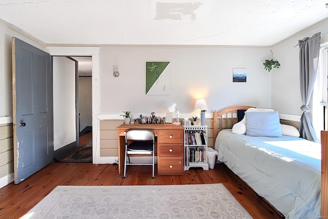 bedroom with dark wood-type flooring and ornamental molding