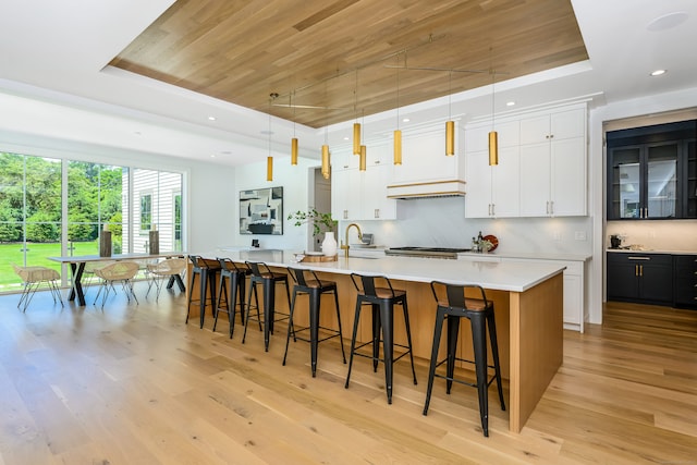 kitchen with decorative light fixtures, white cabinetry, and a large island